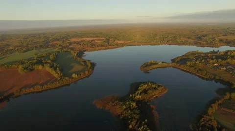 4K aerial view – sunset light over lake and harvested fields in country area Stock Footage 56165386