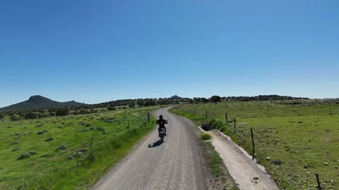 4K Aerial view tracking behind a motorcycle riding on a rural path Spain Stock Footage 336205376
