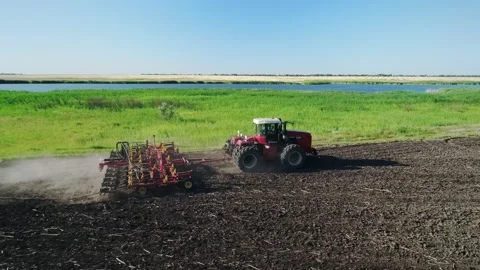 4K. Aerial view of a tractor with a seeder working on a large field Stock Footage 197329593