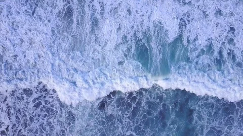 4K aerial view waves breaking on the rocks - cinematic colors at sunrise Stock Footage 77601575