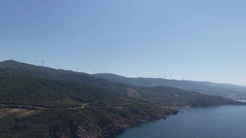 4K Aerial View of Wind Turbines along Coastal Mountain Ridge and Blue Sea Stock Footage 341531789