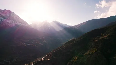 4K Aerial view of zig zag road in rocky landscape on steep cliff, warm sunset li Stock Footage 331525251