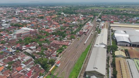 4K aerials fly before train station then fly following dual track railways Stock Footage 272477975