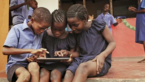 4k of African school students / pupils using tablet computer during lunch break Stockbeeldmateriaal 199625013