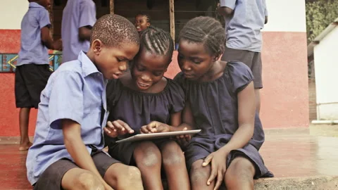 4k of African school students / pupils using tablet computer during lunch break Stockbeeldmateriaal 199625043