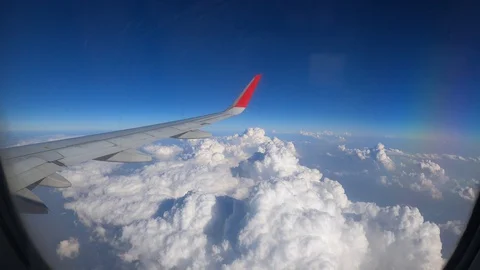 4K Airplane Window Wing View with Clouds and Blue Sky on a  Sunny Day Stock Footage