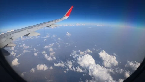 4K Airplane Window Wing View with Clouds and Blue Sky on a  Sunny Day Stock Footage 129536467