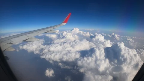 4K Airplane Window Wing View with Clouds and Blue Sky on a  Sunny Day Stock Footage 129536534