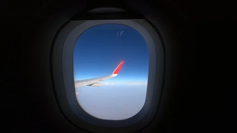 4K Airplane Window Wing View with Clouds and Blue Sky on a  Sunny Day Stock Footage 129536820