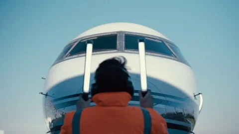 4K Airport worker signaling to airplane pilot on the runway. Stock Footage 72626095