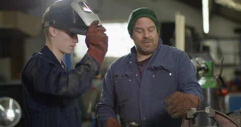 4K Apprentice mechanic learning from experienced worker in auto repairs shop Stock Footage 111638204