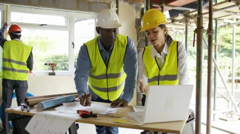 4K Architects with laptop at construction site & building crew working Stock Footage