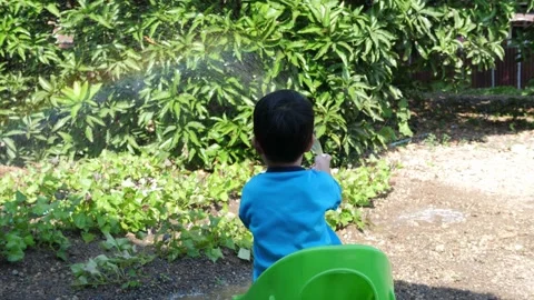 4K Asian child boy making beautiful rainbow by water splash and sunlight Video stock 145753151