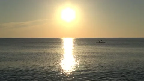 4K ASMR Two Paddleboarding Silhouettes White Gold Ripples under Apricot Sky. Vídeos de archivo 339746772