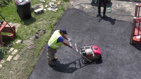 4K Asphalt worker uses smoothing machine to level fresh hot top surface, sound Video stock 125406470