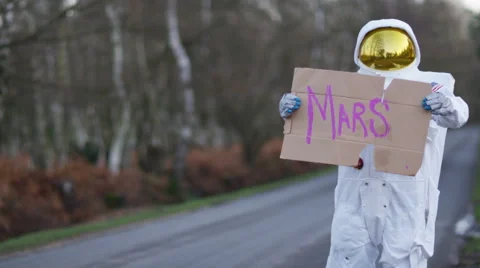 4K Astronaut returned to earth trying to hitch a ride from passing traffic Stock Footage 60766316