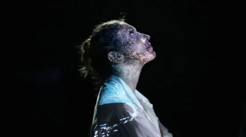 4K Astronomer looking up to sky with telescope & stars projected onto her face Stock Footage