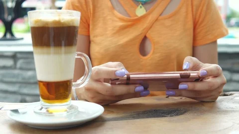 4K Attractive young female using her phone and drinking from a coffee cup at a 動画素材 91970053