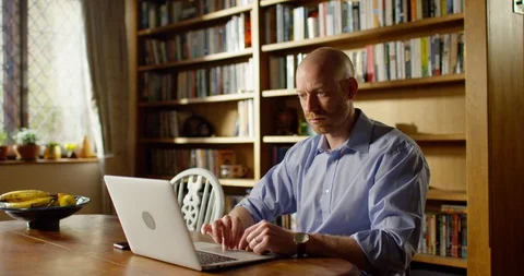4k An attractive young man working from home on his laptop Stock Footage 128362138