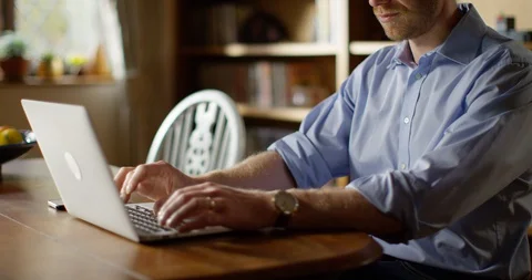 4k An attractive young man working from home on his laptop Video stock 128363535