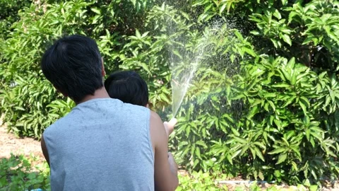 4K Authentic asian child boy and father making beautiful rainbow by water Video stock 145753798