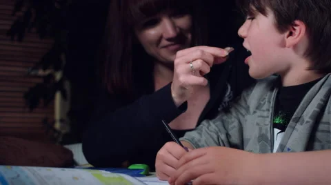 4k Authentic Shot of a Child Doing his Homework and Mum Giving Chocolate Stock Footage