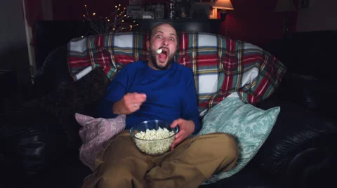 4k Authentic Shot of a Funny Man Watching Horror Movie with Popcorn Stock Footage