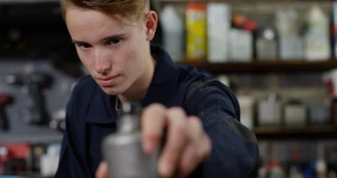4K Awkward apprentice mechanic messing up in garage workshop Stock Footage 113115406