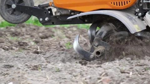 4K B-Roll Rototiller Tines Churning Dark Soil Outdoor Garden Bed Preparatio.. Stock Footage 334583117