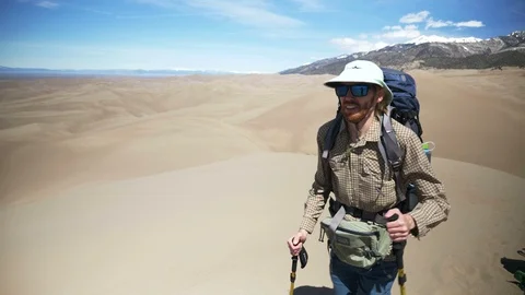 4K Backpacker Walking Onward Past Camera in Sand Dunes National Park Video stock 106190752
