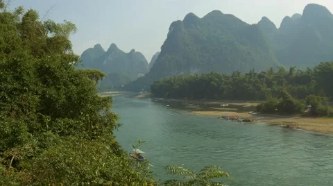 4k, Bamboo raft flowing through the idyllic rural landscape of Yangshuo Stock Footage 64828584