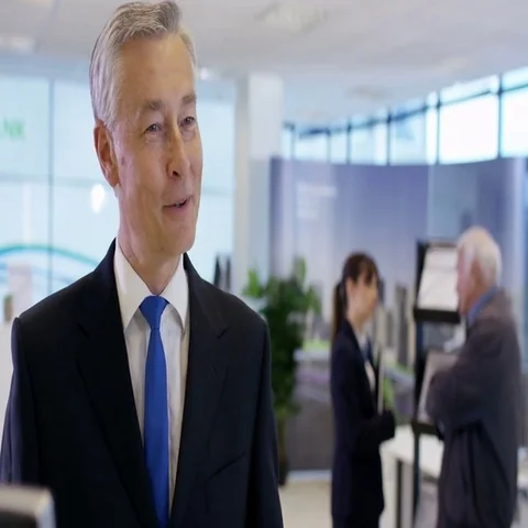 4K Bank worker at service desk assists customer with an account query Stock Footage