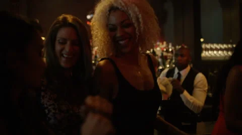 4K Bar staff & party crowd dancing & enjoying the atmosphere in lively nightclub Stock Footage