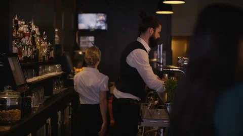 4K Bar Staff Serving Drinks &amp; Female Friends Chatting In City Bar. Stock Footage 75772796