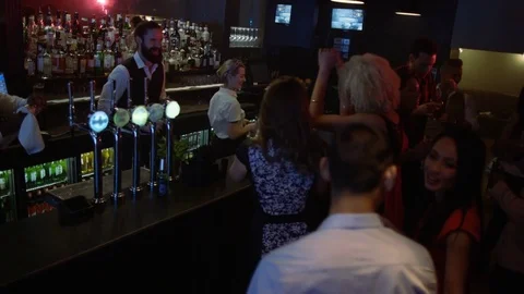 4K Bar Staff Working &amp; Young Party Crowd Dancing In Nightclub Video stock 75650904