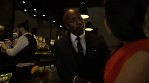 4K Bartender taking payment for drinks from smartly dressed man 库存影片 64910507
