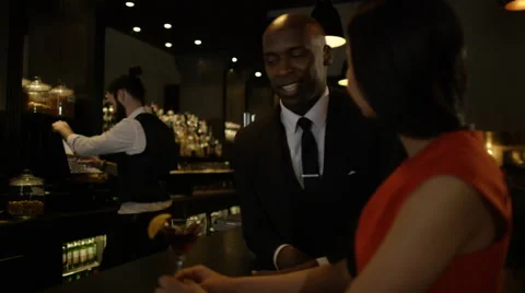 4K Bartender taking payment for drinks from smartly dressed man 库存影片 64910922