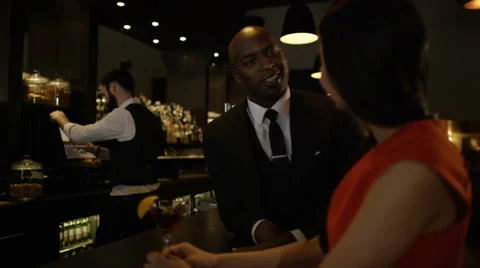 4K Bartender taking payment for drinks from smartly dressed man 库存影片 64911531