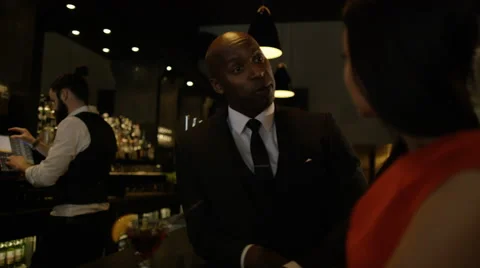 4K Bartender taking payment for drinks from smartly dressed man 库存影片 64912201