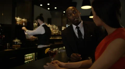 4K Bartender taking payment for drinks from smartly dressed man 库存影片 64961974