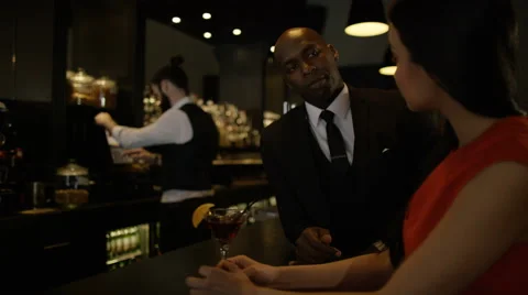 4K Bartender taking payment for drinks from smartly dressed man 库存影片 64963054