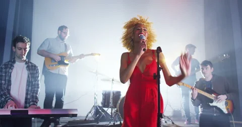 4K Beautiful charismatic female singer performing with band at live music event Stock Footage