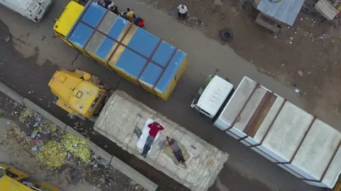4k bird eye view of a man sleeping on a moving truck in lagos traffic. Stockbeeldmateriaal 166903140
