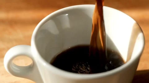 4K Black Coffee Pouring into White Ceramic Cup with Surface Foam Close Up Stock-Footage 339267738