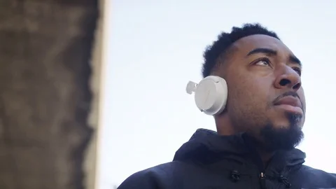4K Black male listening to music on his wireless headphones Stock Footage