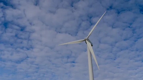 4K, blades of a windmill spinning over a sky full of small white clouds Stock Footage 106929619