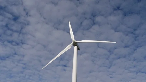 4K, blades of a windmill spinning over a sky full of small white clouds Stock Footage 106929657