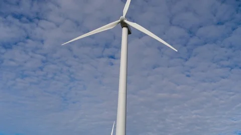 4K, blades of a windmill spinning over a sky full of small white clouds Stock Footage 106929721