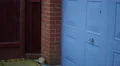 4K blue garage door opening to reveal buckets in fenced garden 4k or 4k+ Resolution