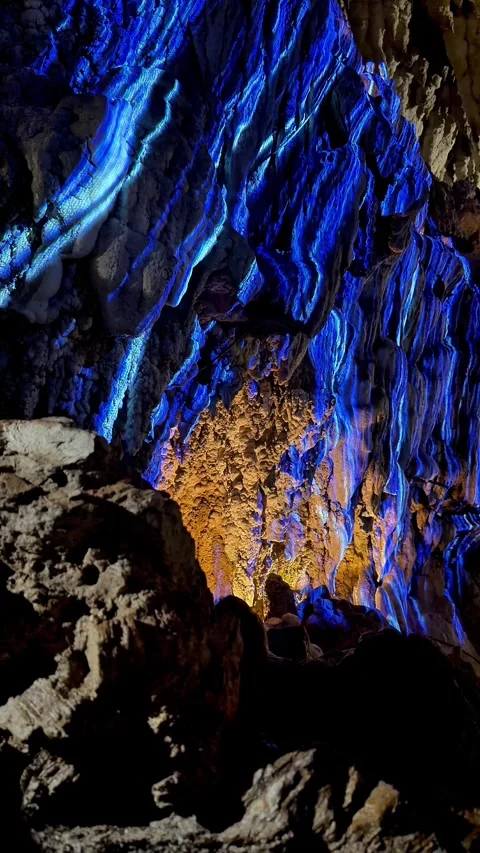 4K Blue-Illuminated Cave Stalactites with Orange Rock Formations, Okinawa, Japan Stock Footage 345375898